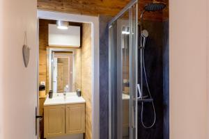 a bathroom with a shower and a sink and a mirror at La Petite Chaumière avec sauna in Saint-Maurice-sur-Moselle +25 photos