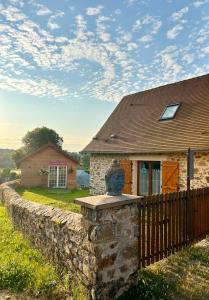 a stone wall in front of a house at Gite Cosy Forme et Bien-etre in Masseret
