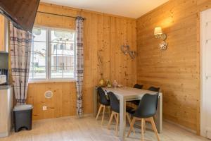 a dining room with wooden walls and a table and chairs at La Petite Chaumière avec sauna in Saint-Maurice-sur-Moselle