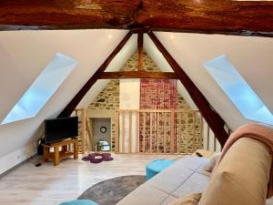 a living room with a roof with skylights at Gite Cosy Forme et Bien-etre in Masseret