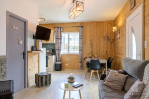 a living room with a couch and a table at La Petite Chaumière avec sauna in Saint-Maurice-sur-Moselle