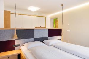 a bedroom with two beds and a tiled wall at Angerle Alm Apt Alpenglühen in Carezza al Lago