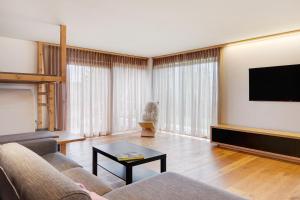 a living room with a couch and a flat screen tv at Angerle Alm Apt Alpenglühen in Carezza al Lago