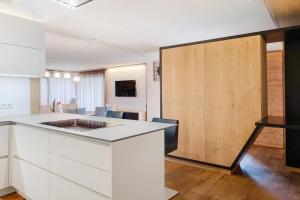 a kitchen with white cabinets and a wooden door at Angerle Alm Apt Alpenglühen in Carezza al Lago