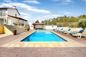 a swimming pool with chairs and a house at Casa de Barqueiros in Barqueiros