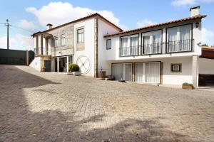a large white house with a cobblestone driveway at Casa de Barqueiros in Barqueiros