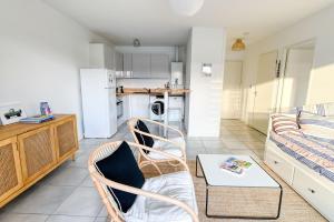 a kitchen and living room with a couch and a table at Senyo Cocoon in Seignosse +12 photos