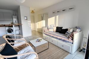 a small living room with a couch and a kitchen at Senyo Cocoon in Seignosse