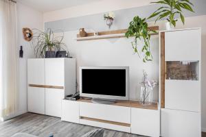 a living room with a tv on a white cabinet at Ferienwohnung am Kappenturm in Hayingen