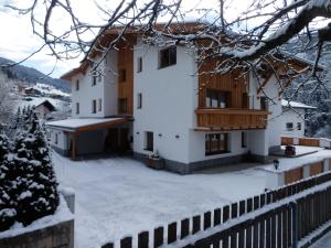 弗利爾施的住宿－Haus Alpenflora，雪中带栅栏的房子