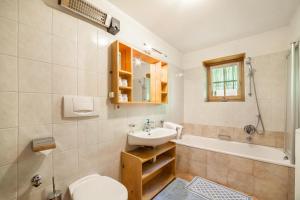 a bathroom with a sink and a toilet and a tub at Ferienhaus Rauchegg - Seeblick in San Pancrazio dʼUltimo