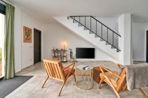 a living room with two chairs and a tv at El Cine in Canillas de Albaida
