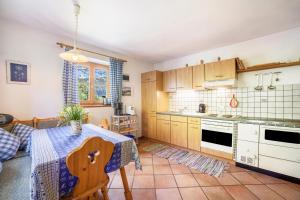 a kitchen with a table with a blue tablecloth on it at Ferienhaus Rauchegg - Seeblick in San Pancrazio dʼUltimo