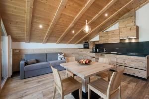 a kitchen and dining room with a table and a blue couch at Natur Suite Edelweisshof App Tony in Chiusa