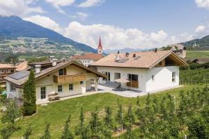 a house in a vineyard with mountains in the background at Natur Suite Edelweisshof App Tony in Chiusa