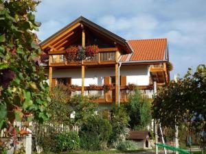 a house with a balcony with flowers on it at Stettnerhof Wohnung Ifinger in Vollan +9 photos