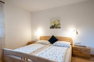 a bedroom with a bed and two night stands at Stettnerhof Wohnung Ifinger in Vollan