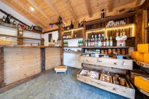a shop with wooden walls and a counter with bottles at Stettnerhof Wohnung Ifinger in Vollan