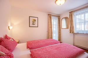 a bedroom with a red bed and a window at Ciasa Tlara App Lisa in San Vigilio Di Marebbe