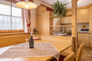 a bottle of wine sitting on a table in a kitchen at Ciasa Tlara App Lisa in San Vigilio Di Marebbe
