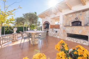 un patio con tavolo e sedie e un camino in pietra di Casa Rural Reme a Navarrés