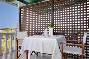 a table and chairs on a porch with a wall at Areti Orfeas Studio in Vasilikos +18 photos