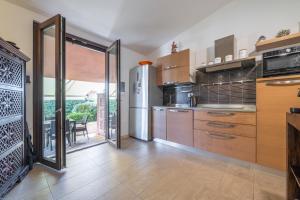 a kitchen with a stainless steel refrigerator and a table at Casa Cò in Costa Rei
