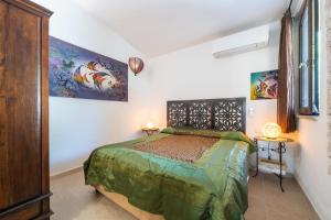 a bedroom with a bed and two paintings on the wall at Casa Cò in Costa Rei