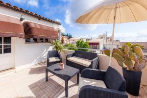 a patio with chairs and an umbrella on a balcony at Casa Varna in Capdepera
