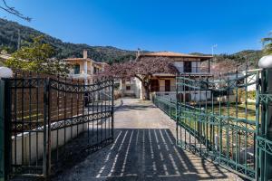 a gate leading to a house with a tree at Villa Votistis A2 in Lefkada