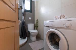 a bathroom with a washing machine and a toilet at Villa Votistis A2 in Lefkada
