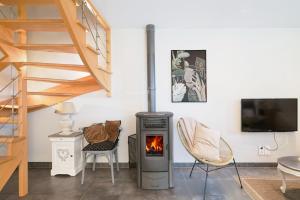 a living room with a wood stove and a staircase at Gîte La Clémençaie in Réminiac