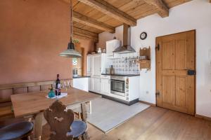 a kitchen with a wooden table and a wooden door at Ferienwohnung Wachsbichl in Unterammergau