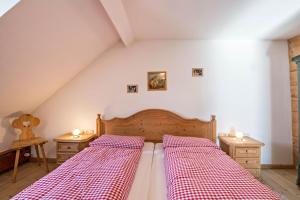 a bedroom with two beds with red and white checkered sheets at Ferienwohnung Wachsbichl in Unterammergau