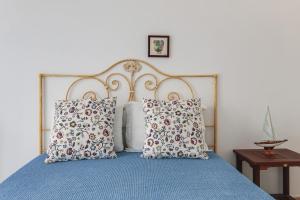 a bedroom with a blue bed with two pillows at Sail Away in Quarteira