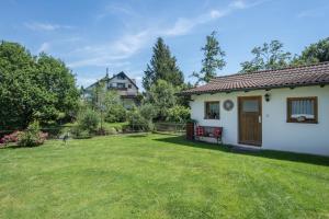 a yard with a white house with a red bench at Haus Schussenblick Og in Eriskirch