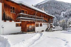 a building covered in snow with a mountain in the background at Chalet Flocke Sternschnuppe in Sankt Anton am Arlberg