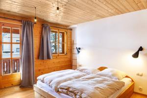 a bed in a bedroom with a wooden wall at Chalet Flocke Sternschnuppe in Sankt Anton am Arlberg