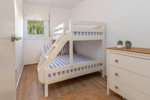 a white bunk bed with a ladder in a room at Brava Beach in Platja d'Aro +13 photos