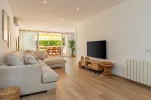 a living room with a couch and a flat screen tv at Brava Beach in Platja d'Aro