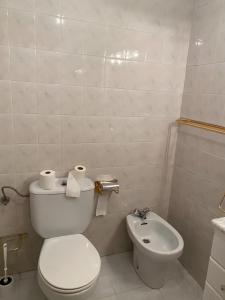 a white bathroom with a toilet and a sink at Montes de Alhama Il in Soria