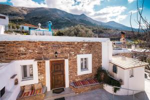 a brick building with a door and mountains in the background at Mannas House in Émbonas