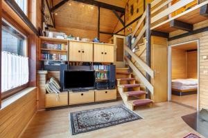 a living room with a staircase and a television at Feriendorf Rechbergblick, Haus 29 in Bernau im Schwarzwald