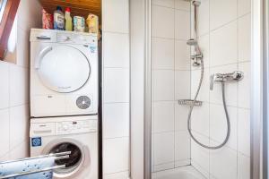a bathroom with a washing machine and a shower at Feriendorf Rechbergblick, Haus 29 in Bernau im Schwarzwald +21 photos