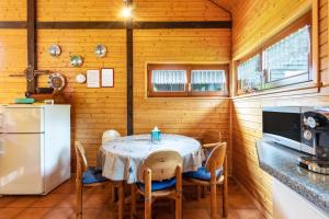 a dining room with a table and a refrigerator at Feriendorf Rechbergblick, Haus 29 in Bernau im Schwarzwald