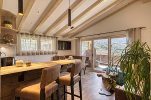 a kitchen and dining room with a large wooden table and chairs at Apfel Chalet Feldhof in Caines