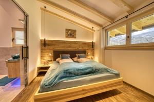 a bedroom with a large bed with a glass wall at Apfel Chalet Feldhof in Caines