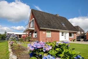 a house with flowers in the front yard at Ferienwohnung Erichsen, Viöl in Viöl