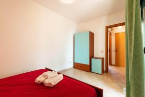 a bedroom with a red bed with a red blanket at Appartamenti Cavour Codice E in Villasimius