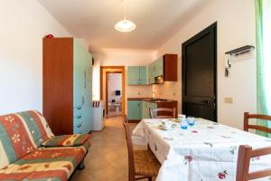 a living room with a table and a kitchen at Appartamenti Cavour Codice E in Villasimius +14 photos
